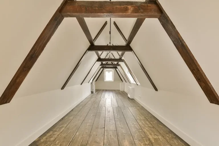 ein Dachgeschossausbau mit Holzbalken und weißen Wänden