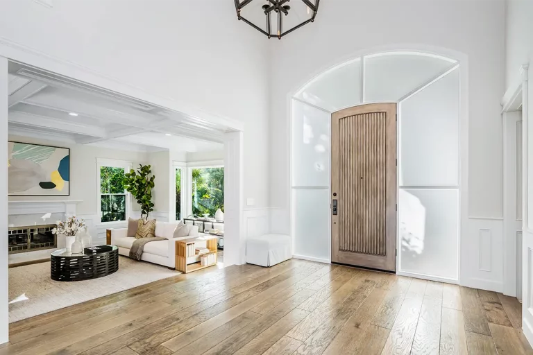 Gut belichteter Eingangsbereich mit Holztür und Fensterbogen