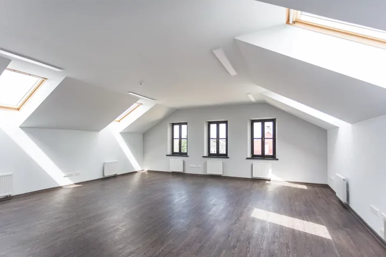 leeres Dachgeschoss-Zimmer mit mehreren Dachfenstern