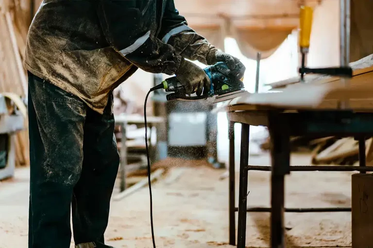 Zimmermann, der in der Werkstatt an Holzhandwerk arbeitet