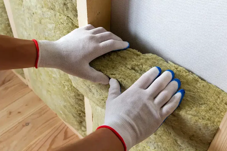 Nahaufnahme von Arbeiterhänden, die Dämmung einbauen