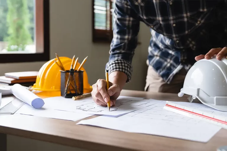 Architekt, welcher an einem Bauplan für ein Haus arbeitet