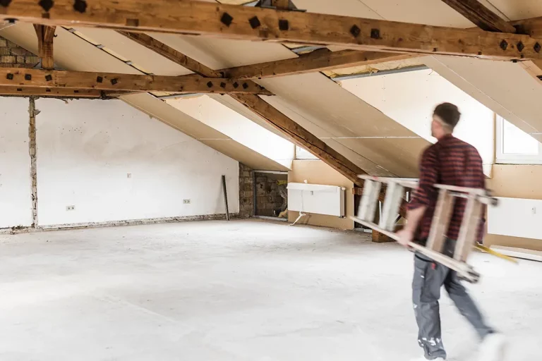 Mann mit Leiter auf einer Baustelle