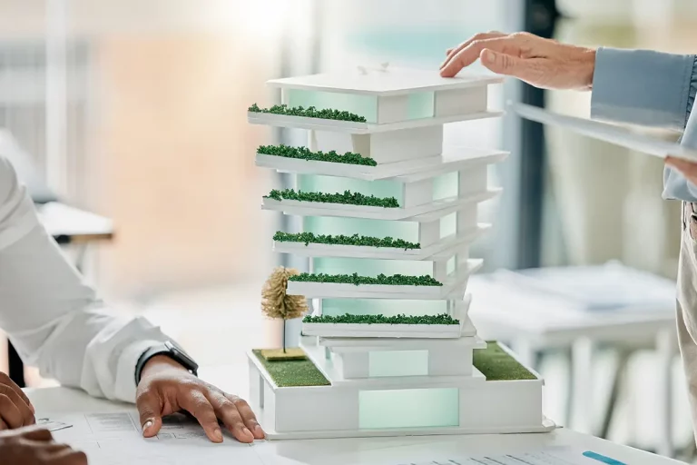 Architekten besprechen ein modernes Gebäudemodell mit begrünten Terrassen