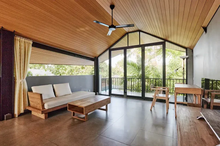 Modernes Wohnzimmer mit Holzdecke, Glasfront und Blick ins Grüne