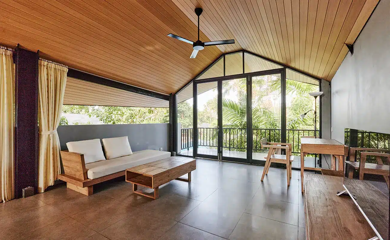 Modernes Wohnzimmer mit Holzdecke, Glasfront und Blick ins Grüne