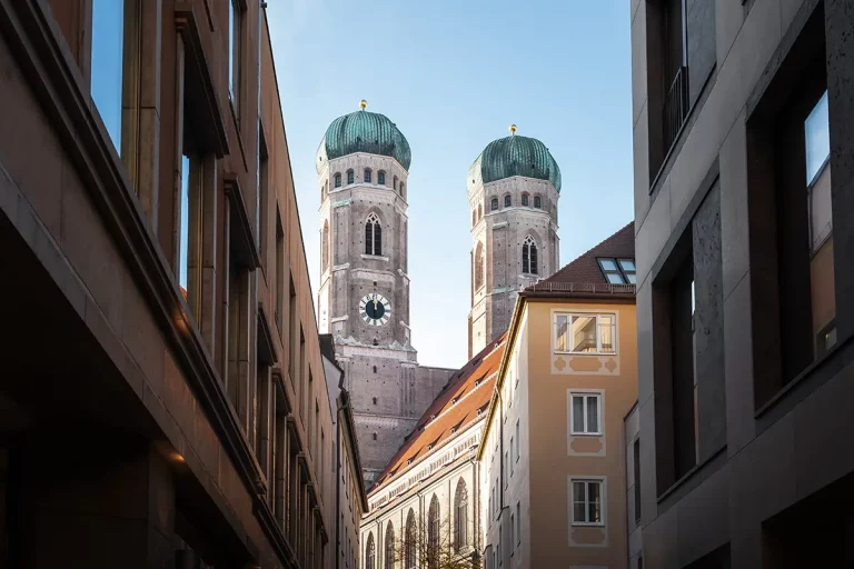 Blick auf die Frauenkirche München zwischen engen Häuserzeilen
